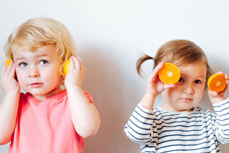 Children posing with organic fruit for EllyPop in Portland, Oregon

