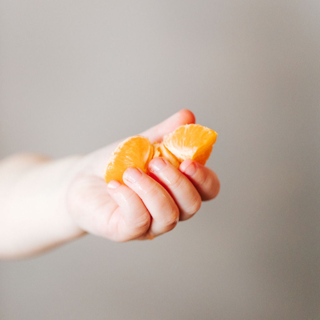 Naturopathic doctor holding fresh cut oranges